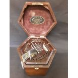 A concertina in very good condition, 24 keys to both sides. In mahogany box with label Boyd & Co.