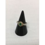 An 18ct yellow gold emerald and diamond ring.