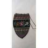 A vintage beaded evening purse with white metal chain hand strap.