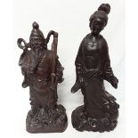 A pair of Chinese wooden sculptures depicting immortals, one male and one female.
