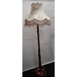 An Art Deco style wooden standard lamp, with shade.