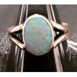 A yellow metal ring, size N, set with a small opal.