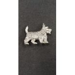 A silver dog brooch
