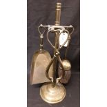 A brass fireplace companion set comprising of brush, tongs and shovel.