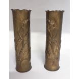A matching pair of WW1 trench art shell case vases elaborately decorated with acorns and foliage.