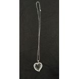 An unusal silver and glass heart shaped locket on silver chain