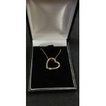 A 9ct yellow gold heart shaped pendant necklace set with a diamond.