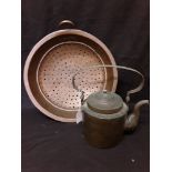 A large copper vegetable strainer together with a copper kettle.