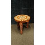 A Indian wooden stool inlaid with shapes of elephants.