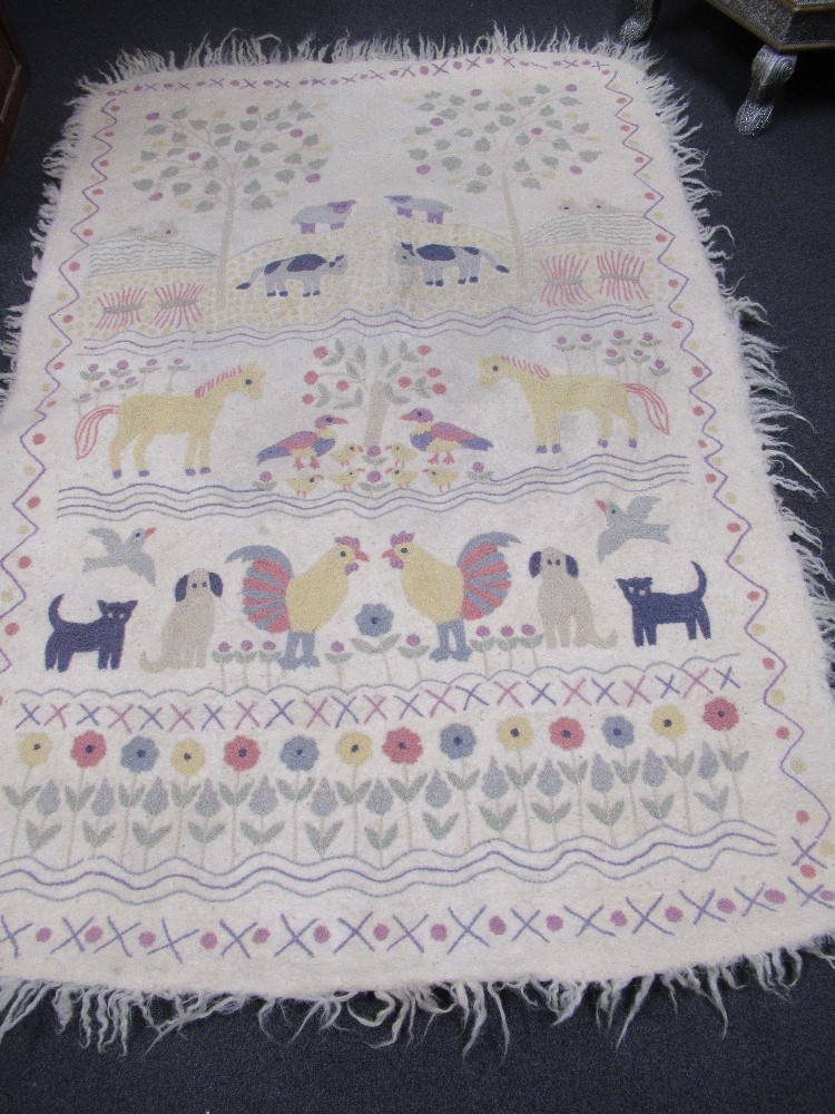 A hand crafted white felted mat/wall hanging beautifully embroidered with animals and flowers.