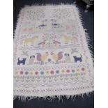 A hand crafted white felted mat/wall hanging beautifully embroidered with animals and flowers.