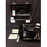 An electric vintage Singer sewing machine, model 222K. Complete with carry case.