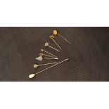 An assortment of 9ct yellow gold and yellow metal hat pins.