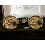 A boxed set of yellow metal cufflinks and matching tie pin set with green jade.