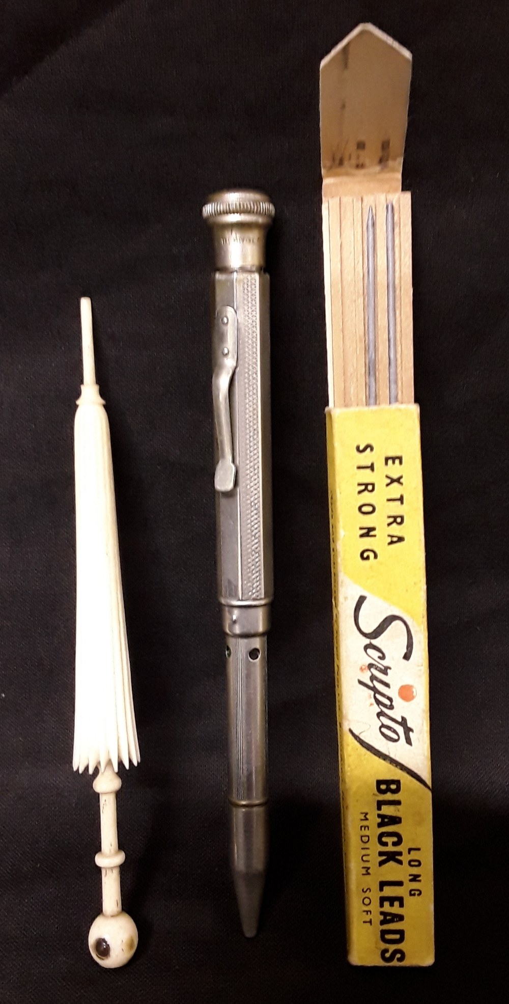 A bone stanhope in the form of an umbrella together with a white metal pencil with leads.