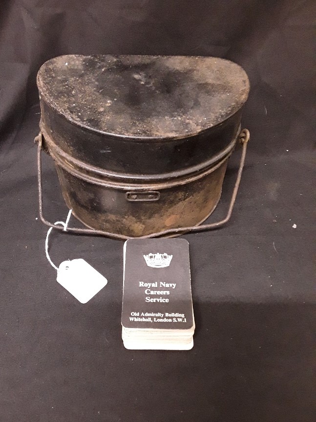 A British military mess food tin and a set of “Royal Navy Careers Service” recognition cards.