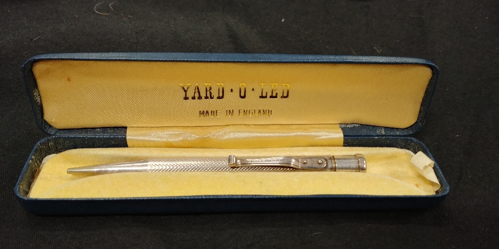 A solid silver pencil marked Yard of Lead. In original presentation case.