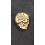 A brass vesta case in the form of a skull.