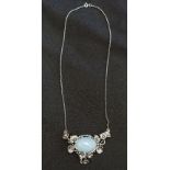 A large silver and moonstone pendant necklace on a silver chain.