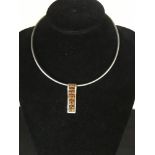 A white metal choker with silver pendant set with alternating pairs of orange & yellow amber stones