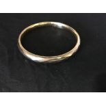 A 9ct gold bangle.