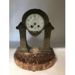 A brass mantel clock on marble base.