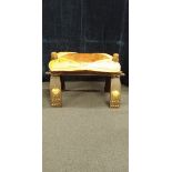 A camel stool with leather cushion decorated with Egyptian heads and art work.