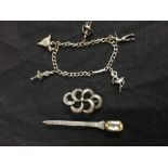 An assortment of silver jewellery including a silver kilt pin, a brooch and a charm bracelet.