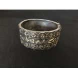 A large silver bangle decorated with yellow and rose gold coloured metal.