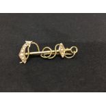 A 9ct yellow gold brooch in the form of an anchor.