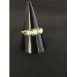 An 18k yellow gold ring set with three fiery Opals the centre stone if flanked by two diamond