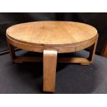 A retro circular coffee table raised on unusual solid cross legs.