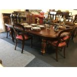 A large mahogany extendable dining table with eight chairs (six plus two carvers).