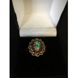 A 9ct gold dress ring set with a central opaline in a daisy setting.