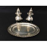 A pair of white metal salt and pepper shakers marked to the base, with white metal tray.