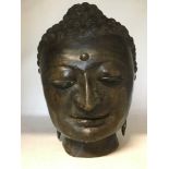 A cast metal head in the form of a Hindu deity.