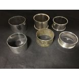 A collection of six solid silver napkin rings of varying ages.