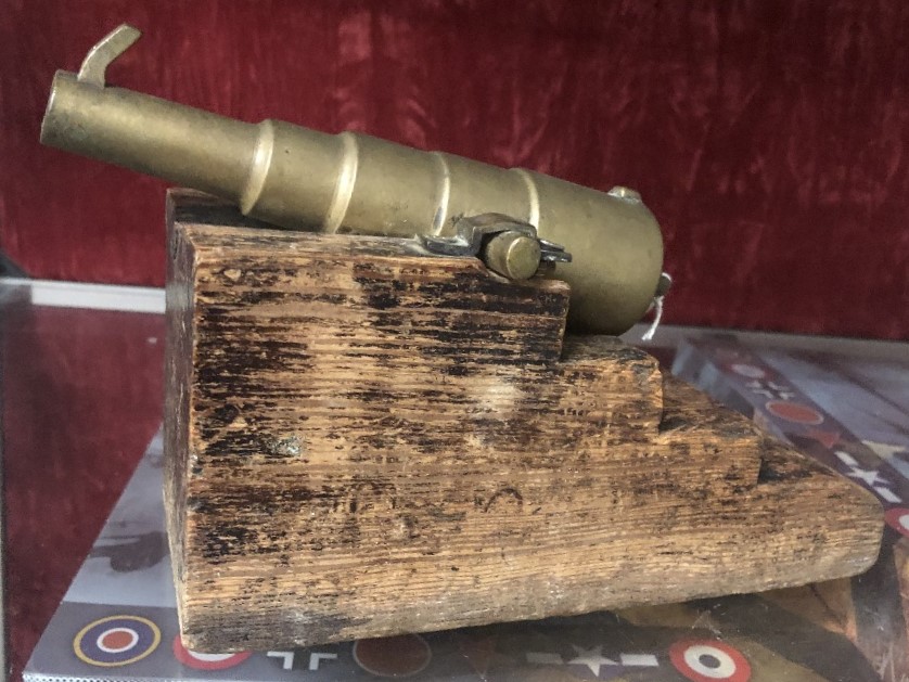 A 19th century bronze signal cannon with front and rear sights mounted on a solid wood carriage.