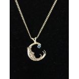 A 9ct gold chain with a yellow metal moon pendant.