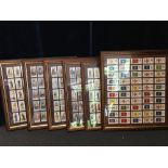 A set of six framed and glazed cigarette cards depicting military themes.