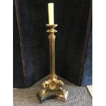 A table lamp with brass fluted column raised on tripod legs terminating in paw feet supported on a m