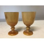 Two horn shot glasses in the form of wine glasses.