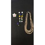 A collection of costume jewellery including a porcelain brooch, faux pearls and vintage earrings.