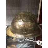 A WW2 French Adrian helmet with brass plaque attached to the visor indicates wearer served in WW1.