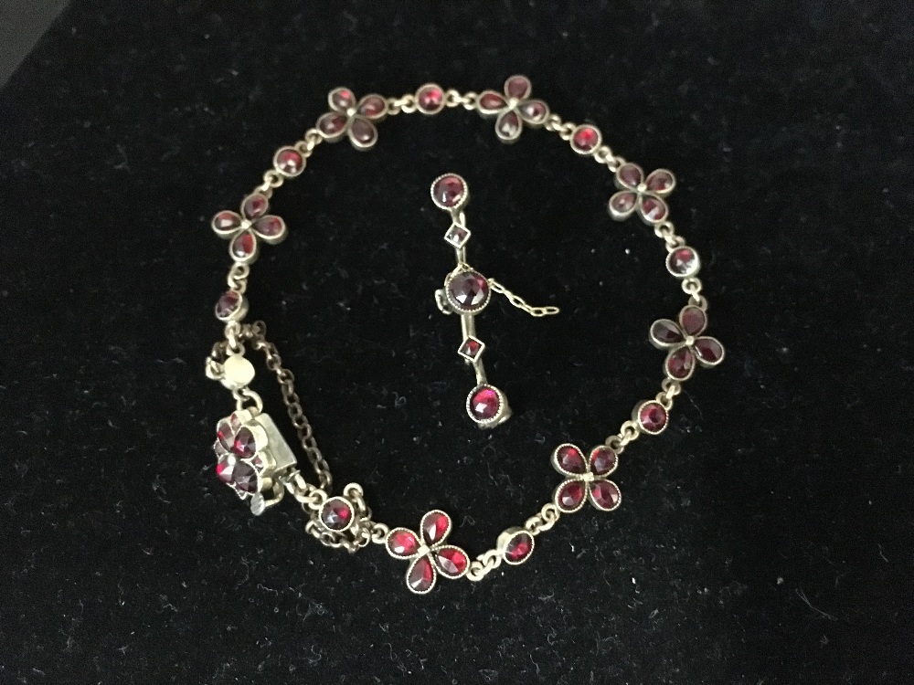 A yellow metal bracelet set with garnets together with matching bar brooch.