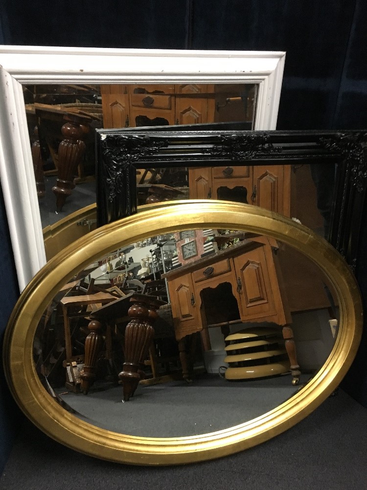 A set of three wall hanging mirrors. One oval and two rectangular.