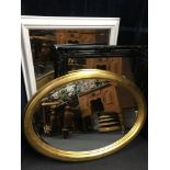 A set of three wall hanging mirrors. One oval and two rectangular.