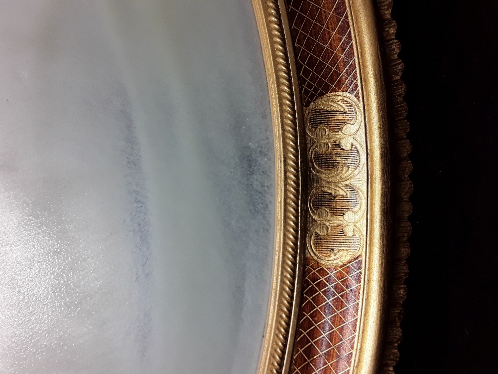 A large oval shaped mirror with bevelled edge to the glass enclosed in a gilded patterned frame. - Image 3 of 3