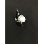 A silver dress ring set with CZ and a large freshwater pearl.