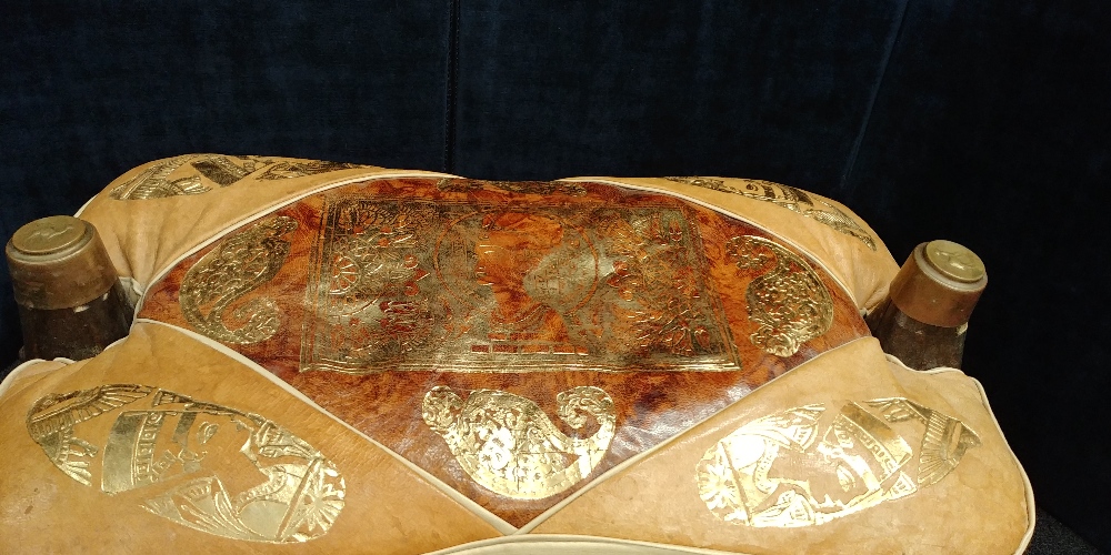 A camel stool with leather cushion decorated with Egyptian heads and art work. - Image 2 of 2